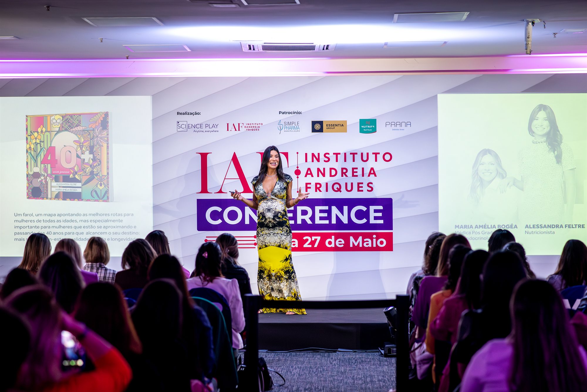 Alessandra no palco diante da plateia em uma conferência